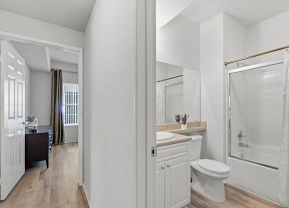 A white bathroom with a toilet, sink, and bathtub.