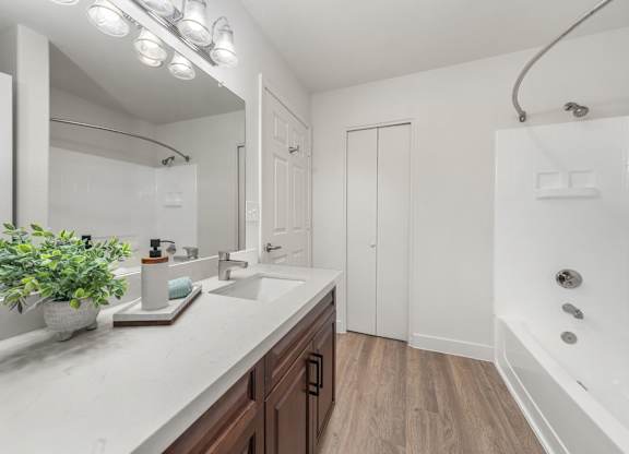 en-suite bathroom featuring upgraded countertops and a relaxing soaking tub