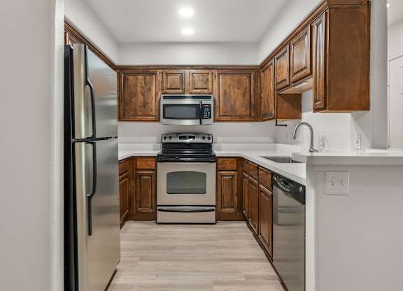 A kitchen with wooden cabinets and stainless steel appliances.