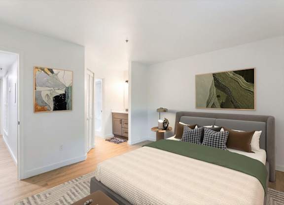 A bedroom with a large bed and two paintings on the wall.