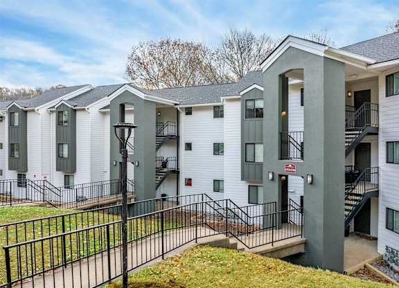 A row of white houses with black railings and steps leading to the doors.