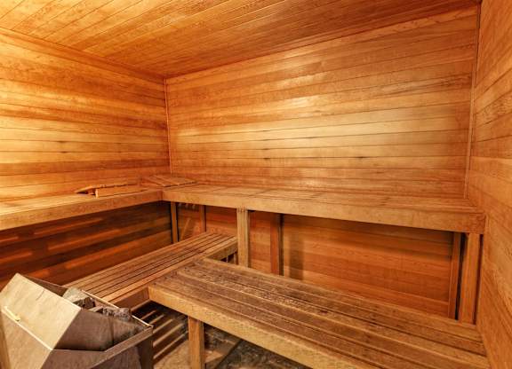 A wooden sauna with benches and a table.