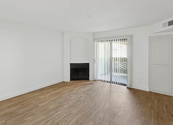 A room with a fireplace and a sliding glass door.
