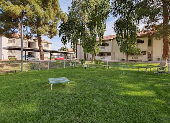 A park with a green lawn and a bench.