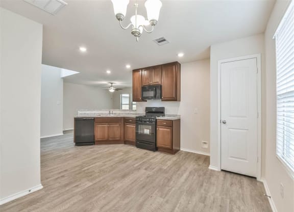 a living room with a staircase and a kitchen at The Village at Caney Mills, Texas, 77303