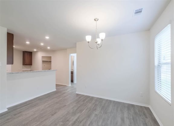an empty living room and kitchen at The Village at Caney Mills, Conroe, Texas