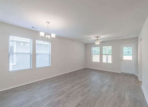 the living room and dining room of an empty house at The Village at Caney Mills, Texas, 77303