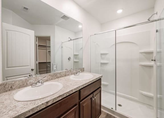 a bathroom with two sinks and a shower at The Village at Caney Mills, Conroe, TX, 77303