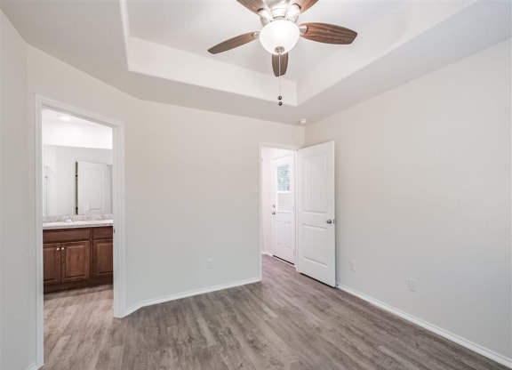 an empty living room with a ceiling fan and a bathroom at The Village at Caney Mills, Conroe, TX, 77303