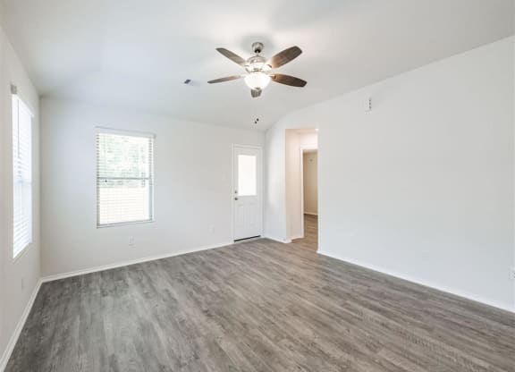 an empty living room with a ceiling fan at The Village at Caney Mills, Conroe, Texas