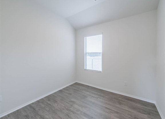 an empty room with wood flooring and a window at The Village at Caney Mills, Texas, 77303