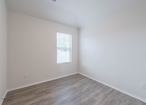 an empty room with white walls and a window at The Village at Caney Mills, Conroe, Texas