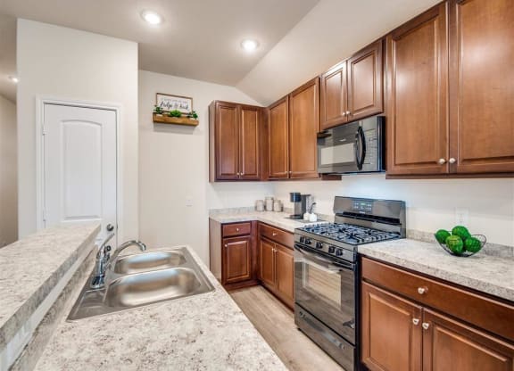 a kitchen with a sink and a stove at The Village at Caney Mills, Conroe, TX, 77303