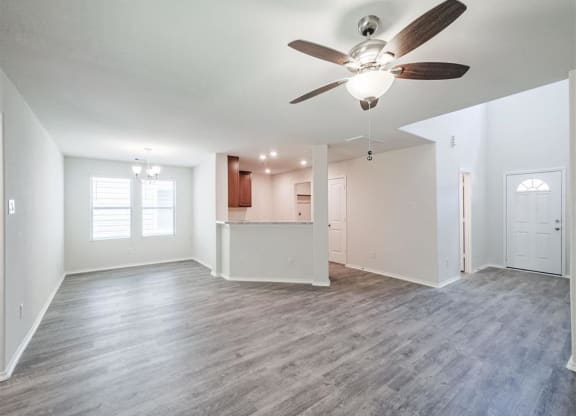 an empty living room with a ceiling fan and a kitchen at The Village at Caney Mills, Texas