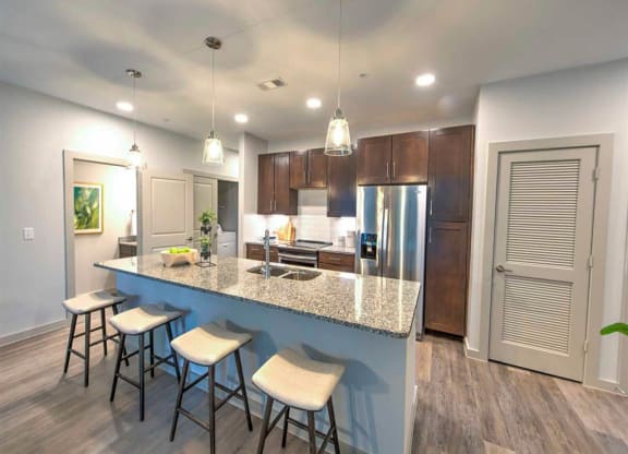 a kitchen with a large island with bar stools