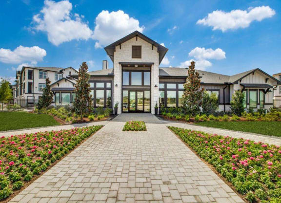the front facade of a large estate home with a brick path leading to the entrance