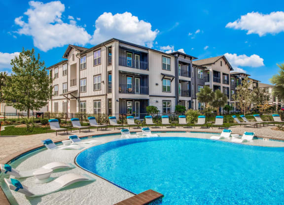 a large swimming pool in front of an apartment building