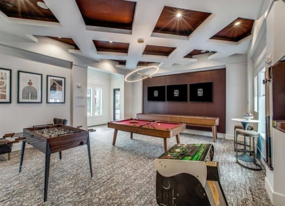a game room with two pool tables and a television