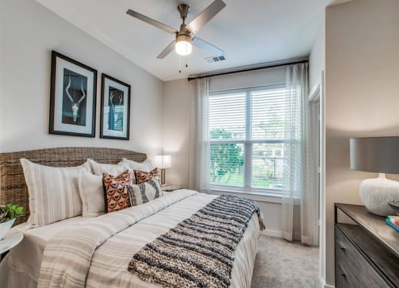 a bedroom with a large bed and a ceiling fan