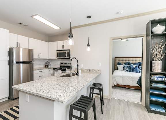 a kitchen with a breakfast bar and a bedroom in the background at Westmount at Ashwood, Georgia
