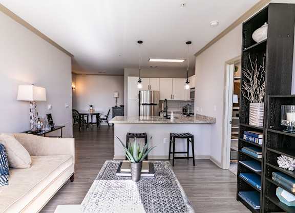 a living area with a couch a coffee table and a kitchen in the background at Westmount at Ashwood, Atlanta