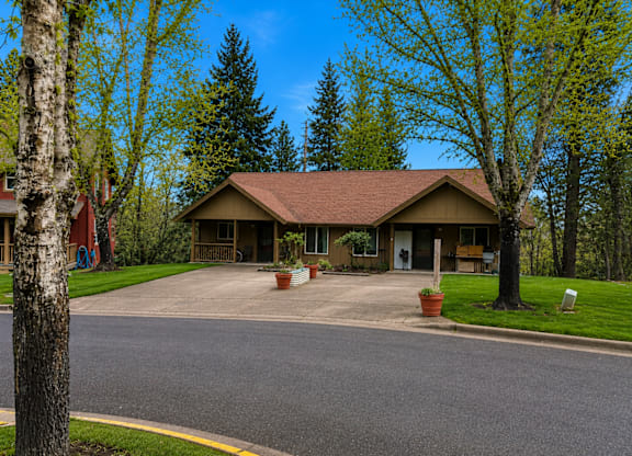 A house with a brown roof and a driveway in front.
