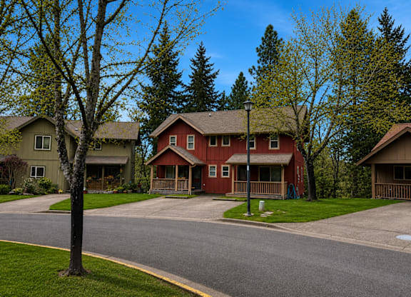 A red house is in the middle of two other houses.