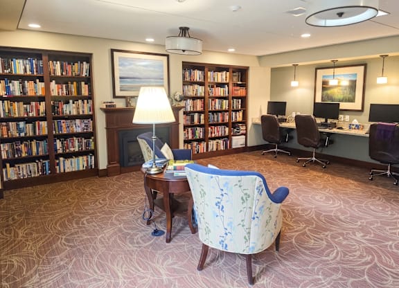 A room with a carpeted floor and a large bookshelf filled with books.