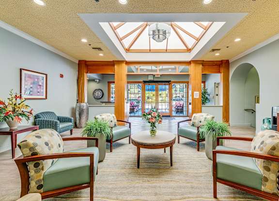 A spacious waiting area with wooden furniture and a glass ceiling.