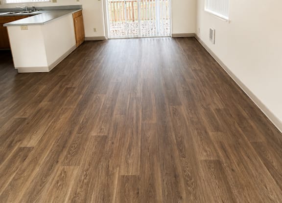 A kitchen with wooden floors and white walls.