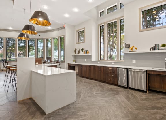 Community Kitchen with a large island and stainless steel appliances and large windows at Mission Gate, Texas, 75024