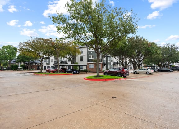 a parking lot with cars parked in front of a building at Mission Gate, Texas, 75024