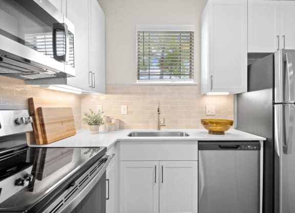 a white kitchen with stainless steel appliances and white cabinets at Mission Gate, Texas