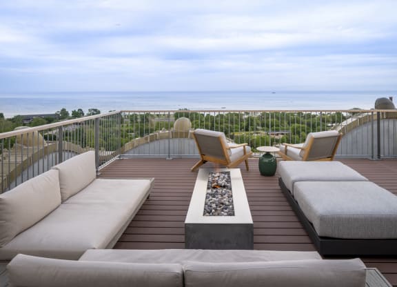 a terrace with couches and chairs overlooking the ocean at the Belden Stratford in Chicago, 60614