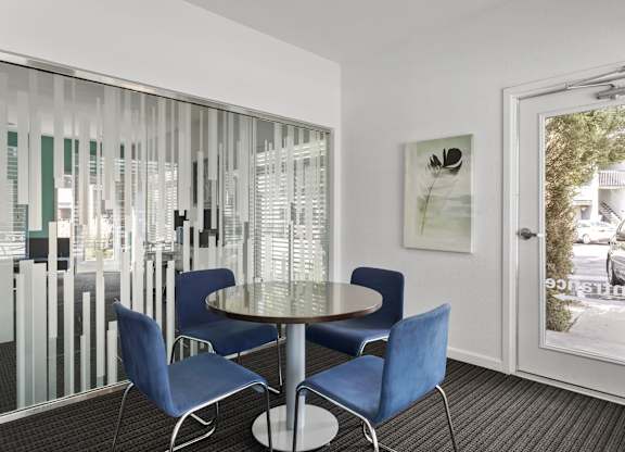 a dining area with blue chairs and a glass table  at Verona, Littleton, 80123
