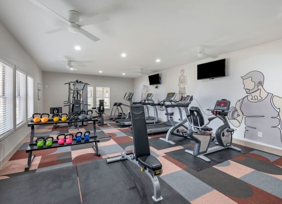 a home gym with exercise equipment and a wall mural of a man on the wall at Paisley and Pointe Apartments, Las Vegas, NV
