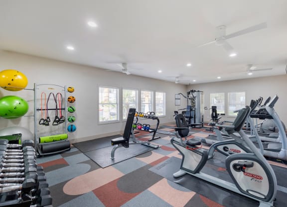 a gym with treadmills and other exercise equipment and windows at Paisley and Pointe Apartments, Las Vegas, 89130