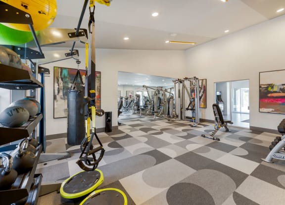 a gym with weights and cardio equipment on a checkered floor at Paisley and Pointe Apartments, Las Vegas, NV 89130