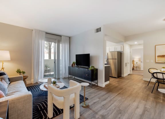 a living room with a couch and a tv at Paisley and Pointe Apartments, Las Vegas