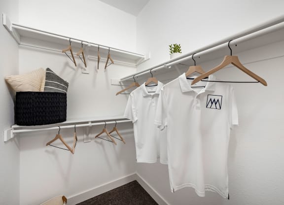 white shirts hanging on a rack in a dressing room at Paisley and Pointe Apartments, Nevada