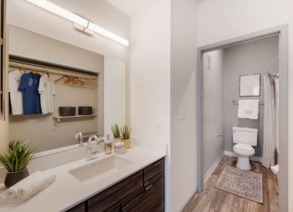 a bathroom with a mirror and a sink and a toilet at Paisley and Pointe Apartments, Las Vegas, NV