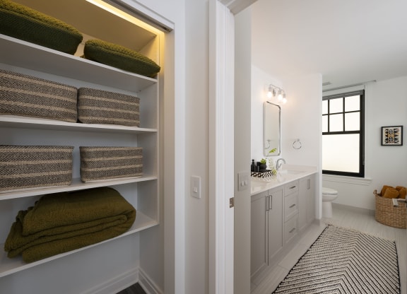 a bathroom with a sink and shelves with towels  at The Belden Stratford, Chicago, 60614