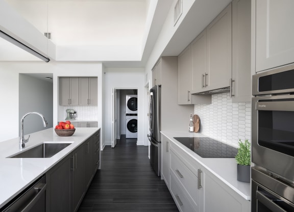 a large kitchen with white counter tops and black appliances  at The Belden Stratford, Chicago, 60614