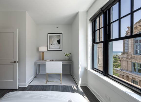 a bedroom with a bed and a desk and large windows  at The Belden Stratford, Chicago, 60614