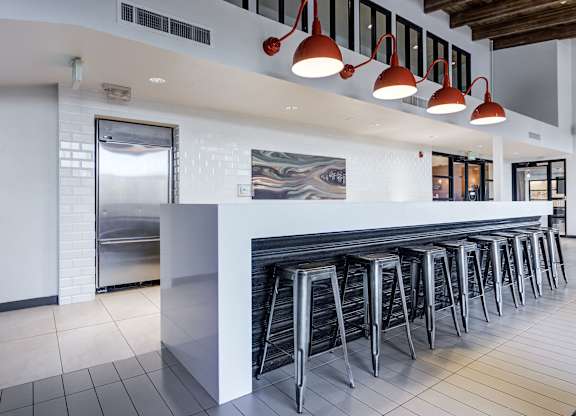a row of bar stools in front of a long bar with white tiles at Ashford Belmar Apartments, Lakewood, 80226