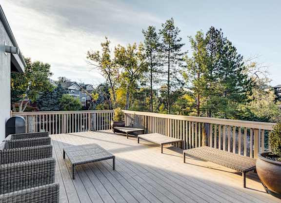 the deck has a view of the mountains and trees at Ashford Belmar Apartments, Lakewood