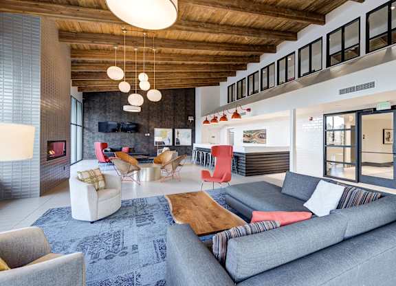 a living room with couches and chairs and a fireplace at Ashford Belmar Apartments, Lakewood, Colorado