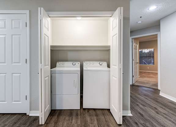 an empty laundry room with two washes and a dryer at Ashford Belmar Apartments, Lakewood, CO