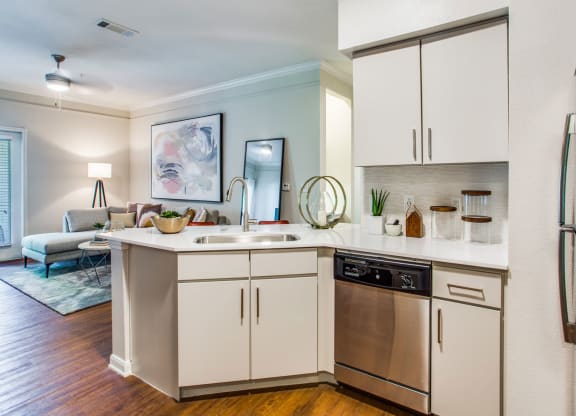 a kitchen with white cabinets and a sink and a dishwasher at Carrington at Barker Cypress, Cypress, TX, 77433