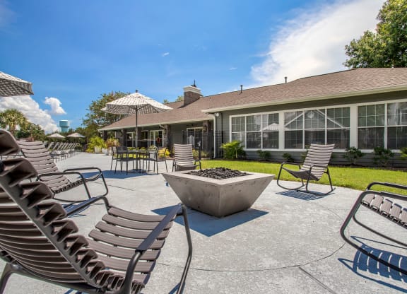 a large patio with chairs and umbrellas in front of the resident clubhouse at Reserve by the Lake, Houston, 77084
